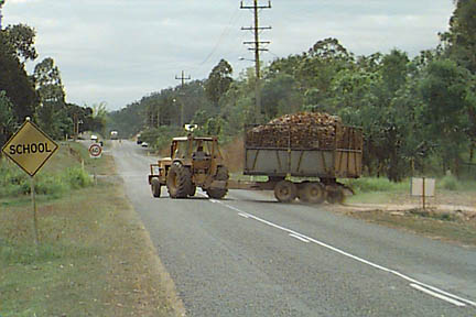 Tractor hauling cane bin on trailer